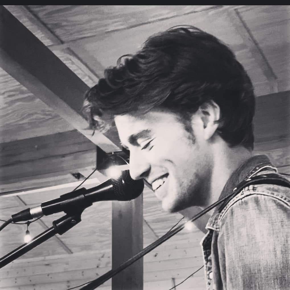 Black-and-white portrait of Jack Ooster singing into a microphone